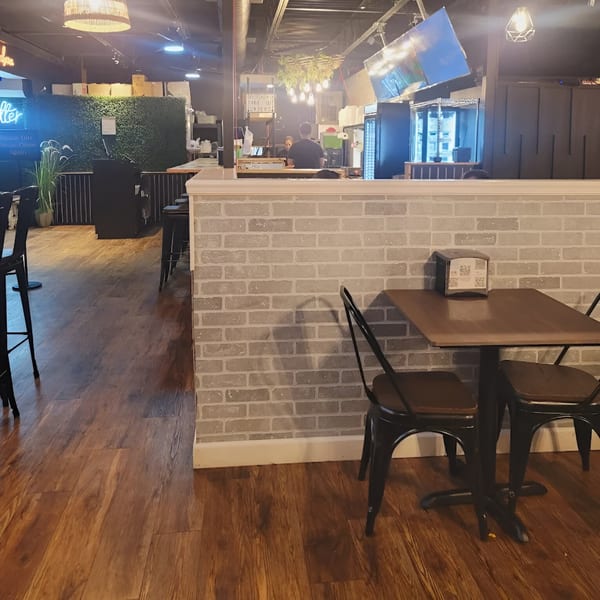 Interior of Cabaña Mexican Grill with tables, chairs, and a counter area with staff.